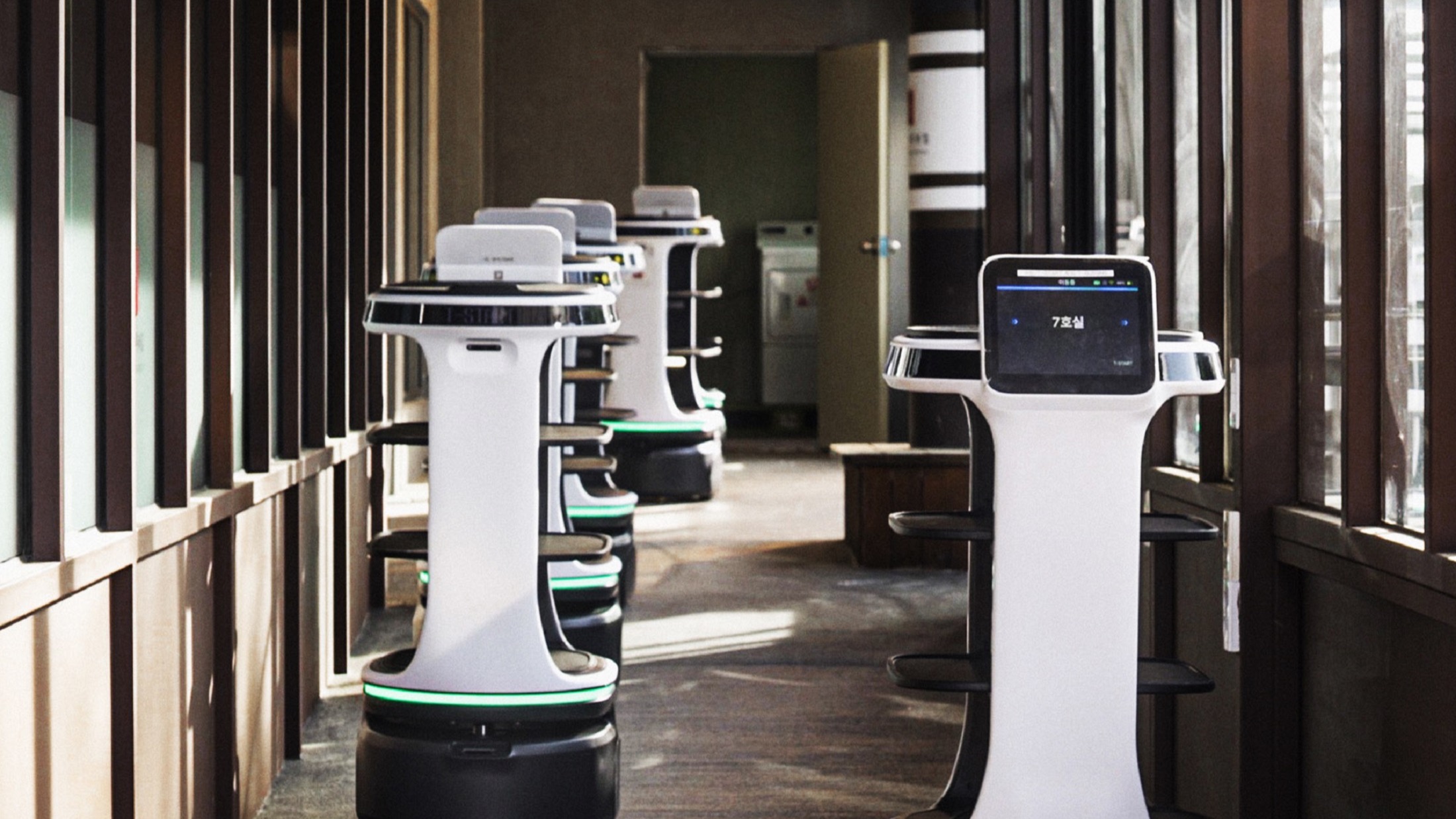 Bear Robotics Servi Plus service robots operating in a hallway