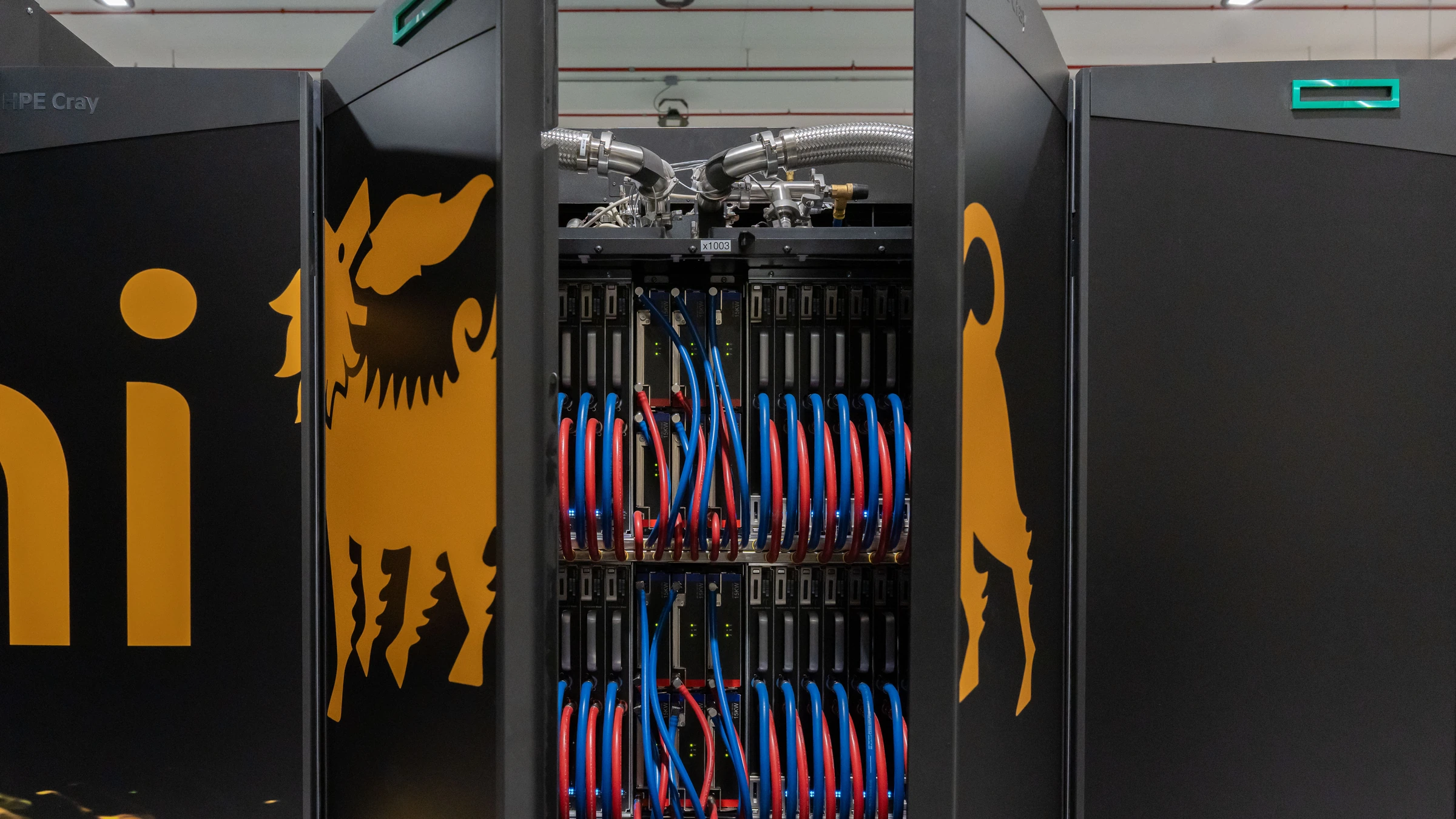 An open HPC6 computer cabinet with red and blue cooling tubes between Eni-branded doors; an existing facility, not a robot trial.