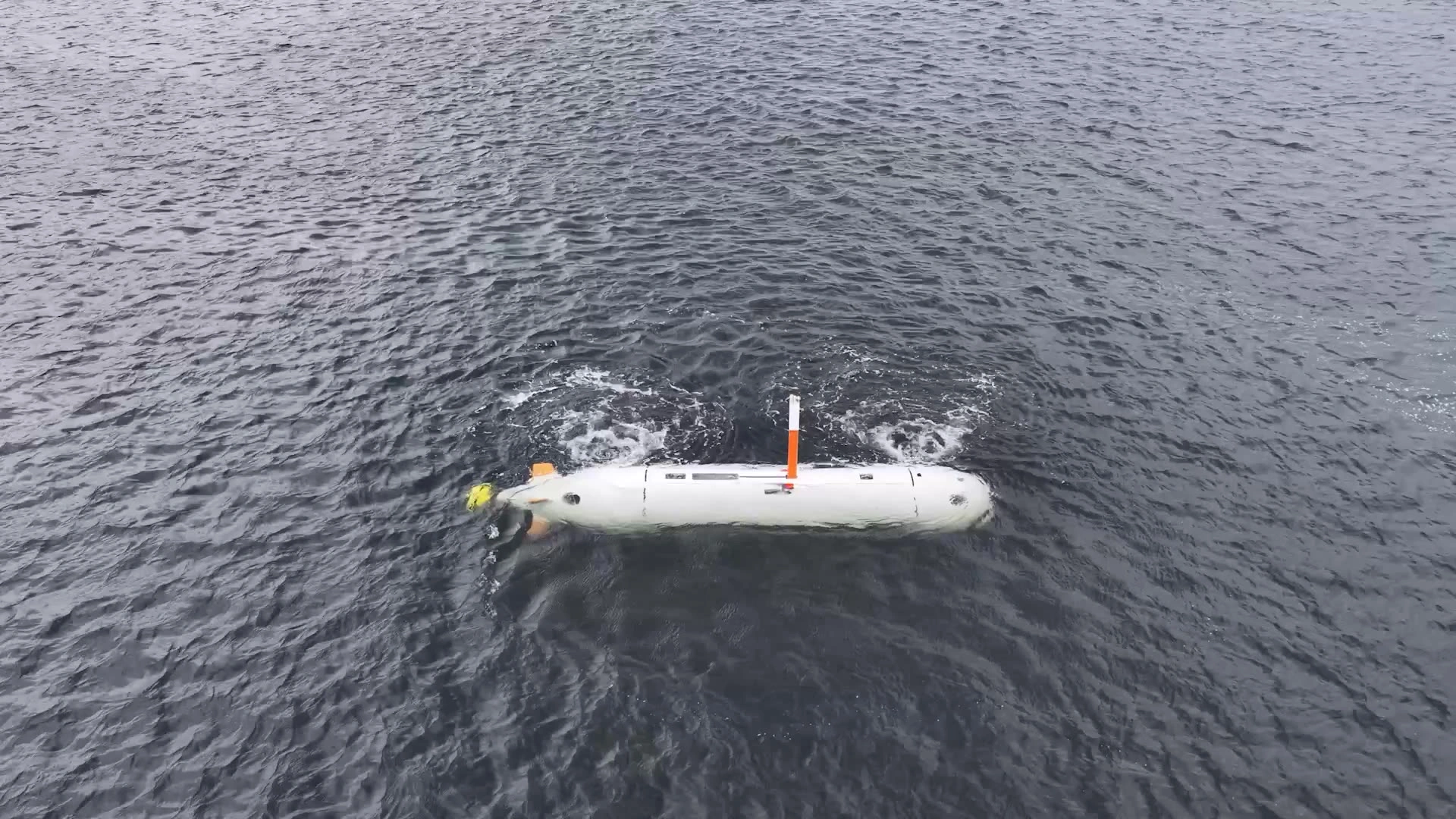 Saab’s white uncrewed underwater demonstrator at the sea surface, in its official LUUV sea-trial B-roll released on 16 October 2026.